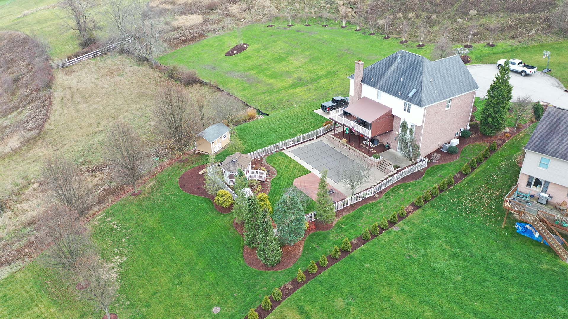 Completed backyard landscape with patio, retaining walls, and plantings in Bethel Park