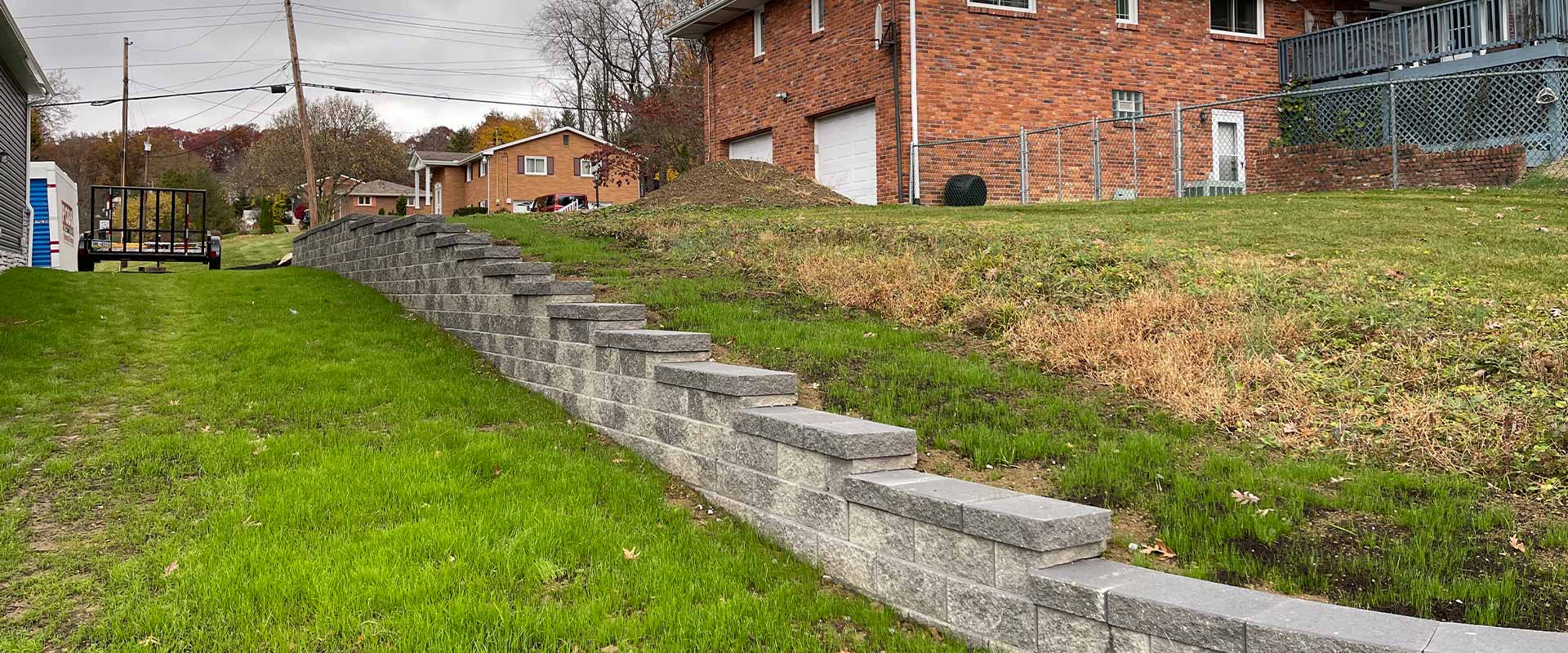 A waist-high retaining wall marks a property line