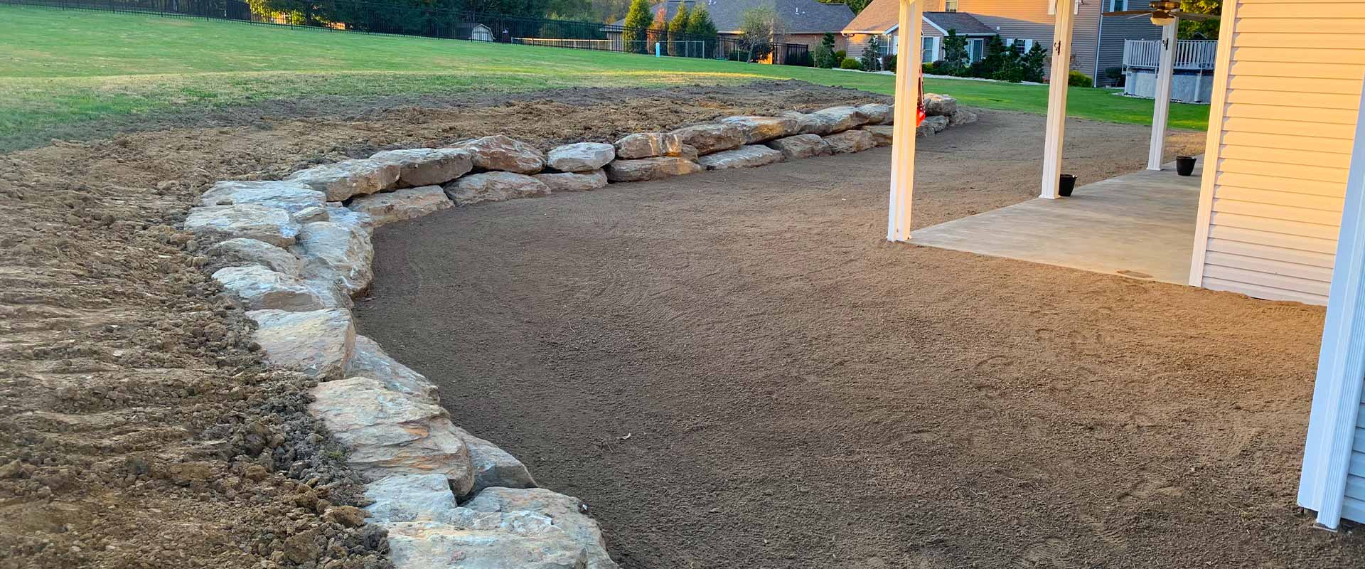 Stone wall surrounds a patio area