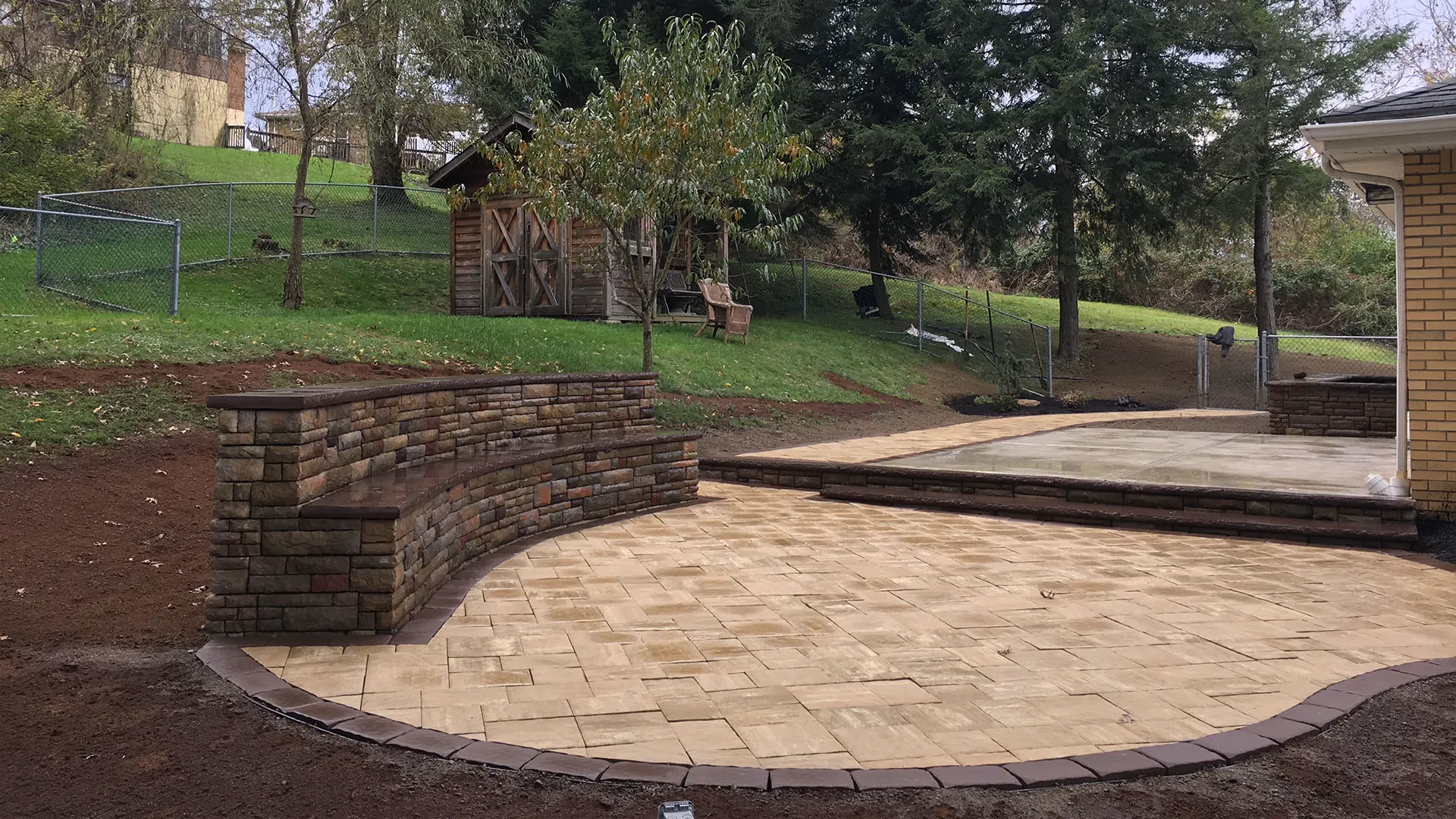 A wet paver patio and steps in a Pittsburgh yard