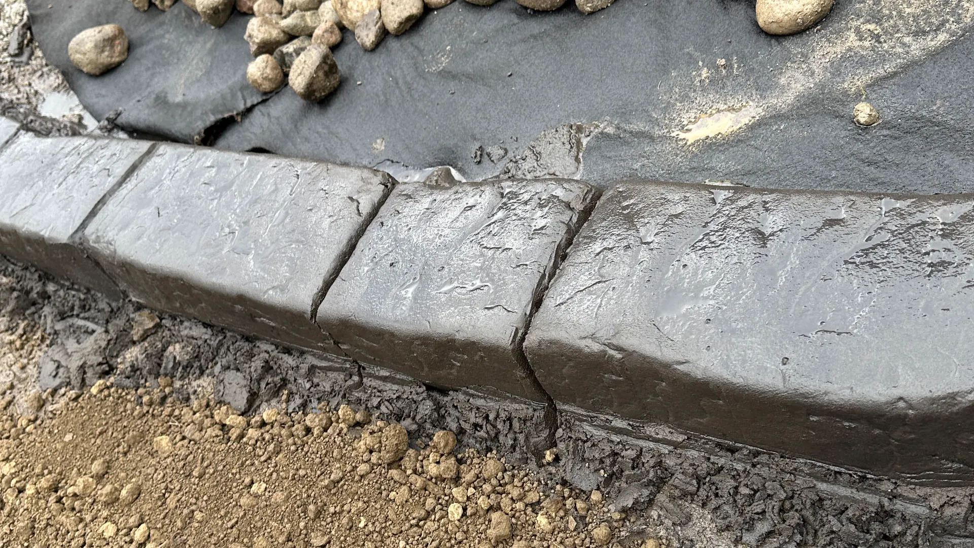 Continuous concrete curbing installed along a landscape bed in Pittsburgh