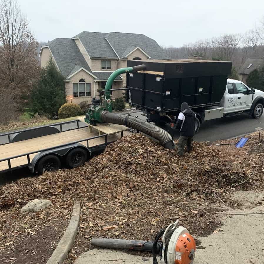 Q&A Landscaping leaf vacuum truck clearing a leaf pile on a fall cleanup