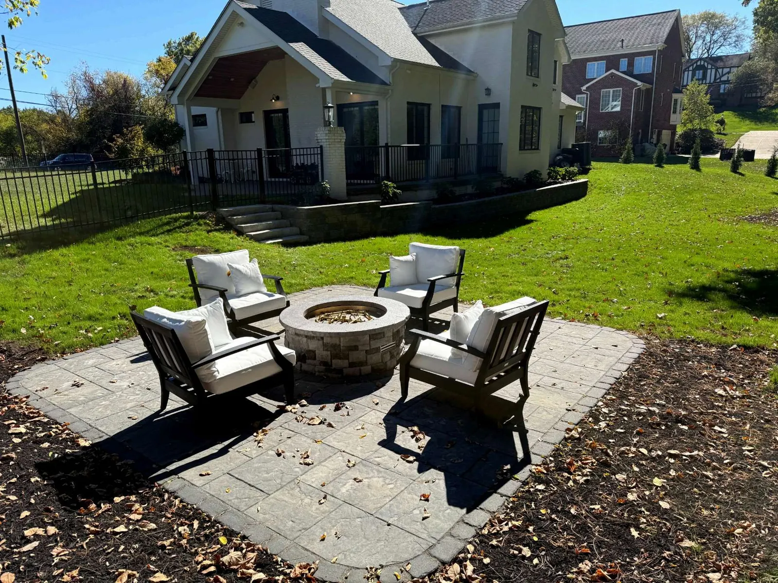 Medium paver patio with a stone firepit and four chairs, finished with a darker border paver