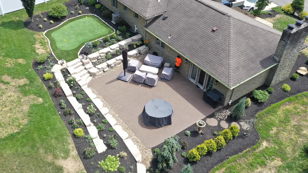 Backyard patio with stone steps, putting green and fresh plantings in Bethel Park