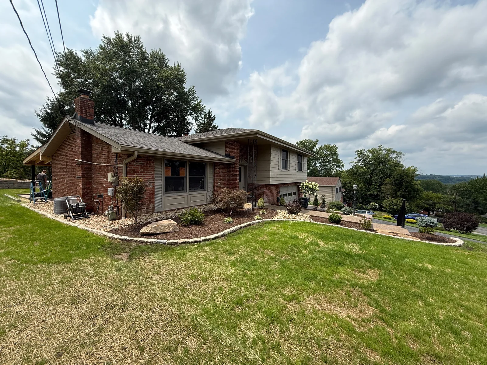 The side of the home with the new curved Belgian block bed edge running along the lawn
