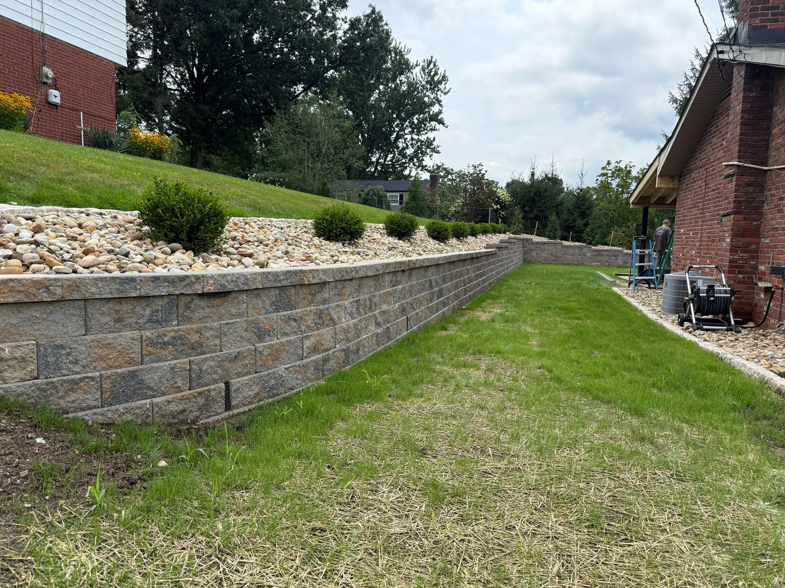New Versa-Lok wall running along the side of the yard beside the lawn