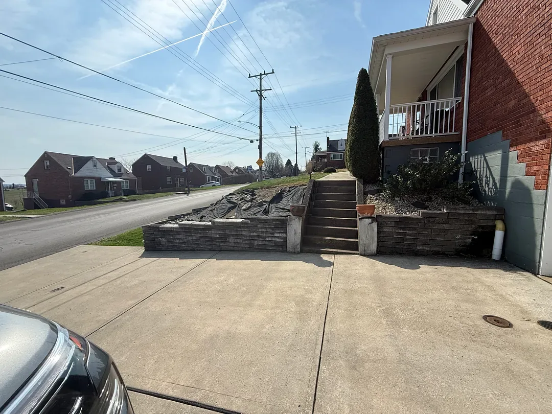 Before: the old front steps running between two old retaining walls, seen from the driveway