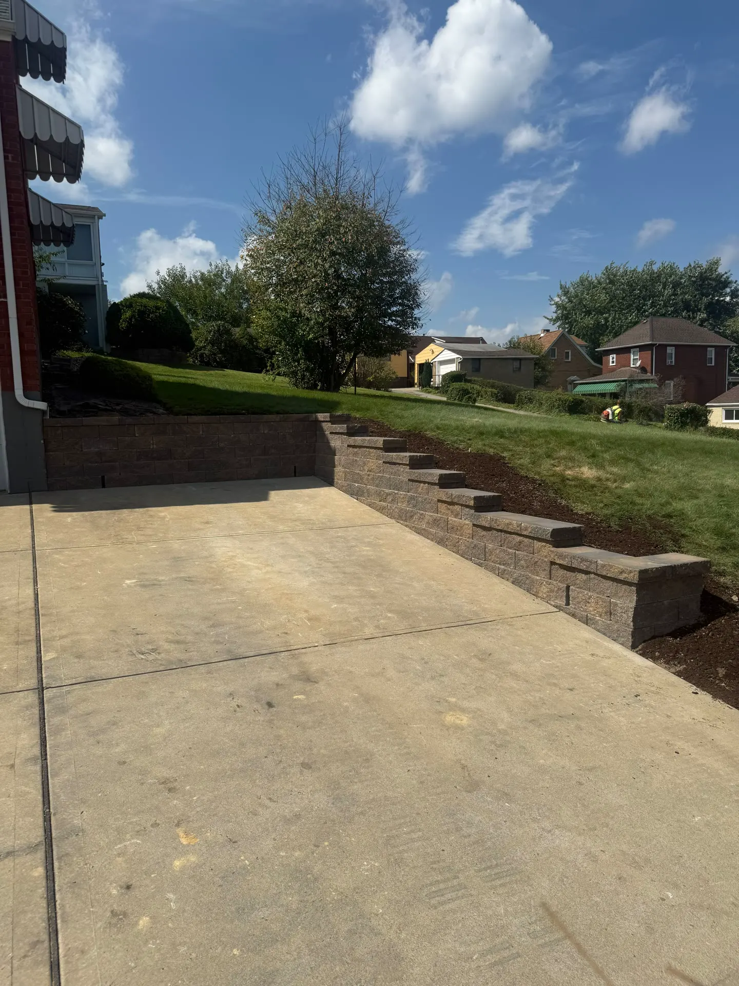 Block retaining wall with built-in steps along a Pittsburgh driveway